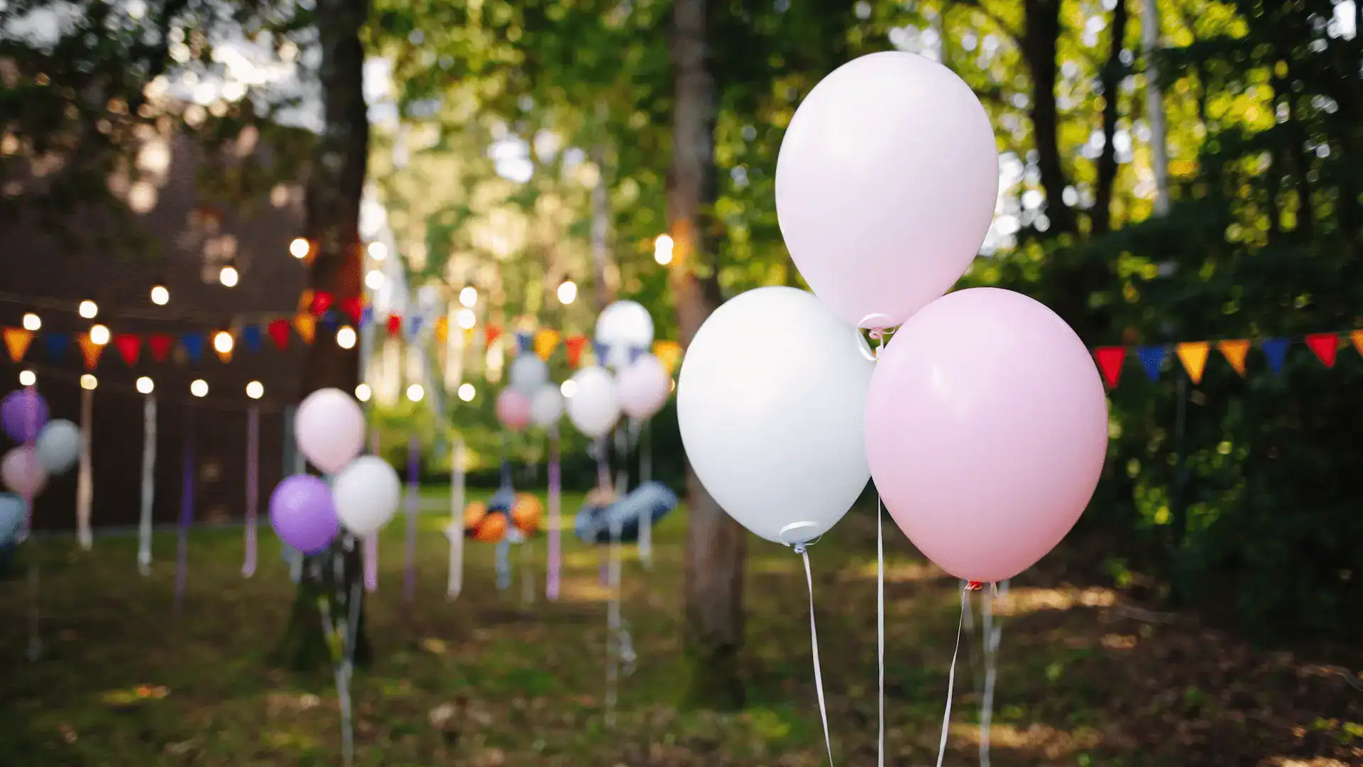 Outdoor birthday party with balloons and flag decor